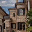 standard exterior architectural black paneled window shutters on a brick home